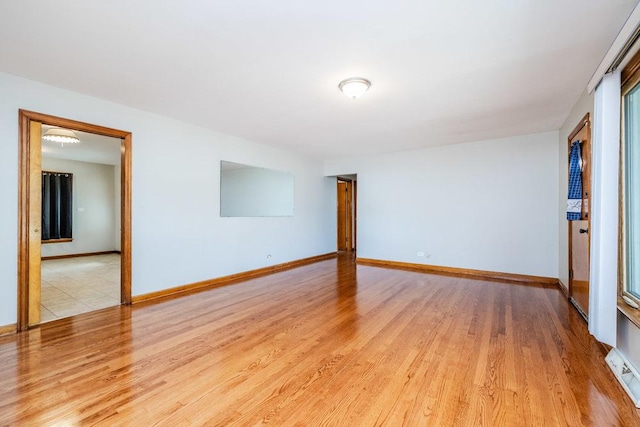 spare room featuring baseboards and wood finished floors