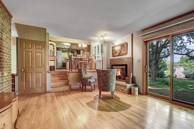 13344 S Stephen Dr, Palos Park, IL 60464 - living area featuring light wood finished floors, a chandelier, stairs, and a lit fireplace