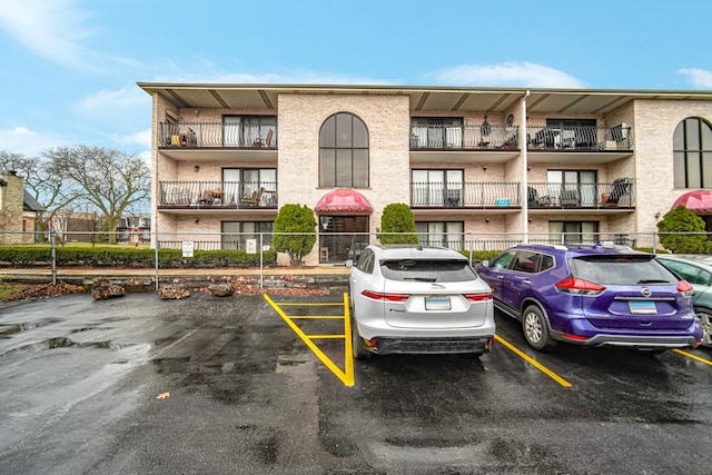 view of property with uncovered parking and fence