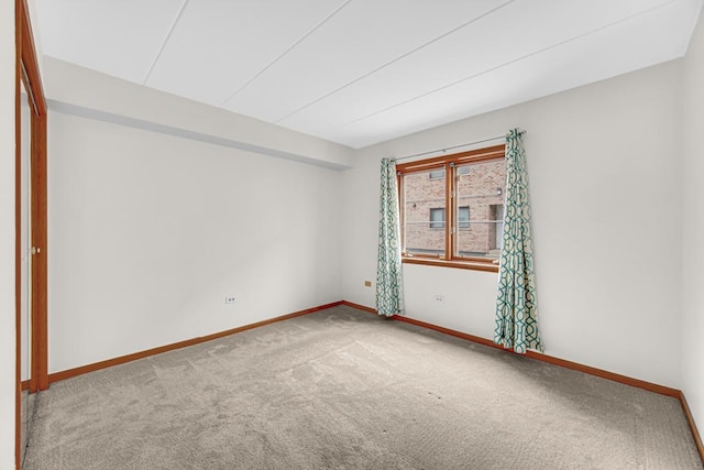 carpeted spare room with baseboards
