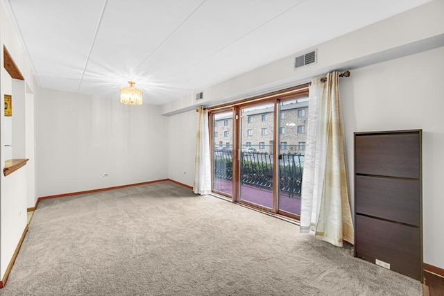 unfurnished room featuring carpet flooring, visible vents, and baseboards