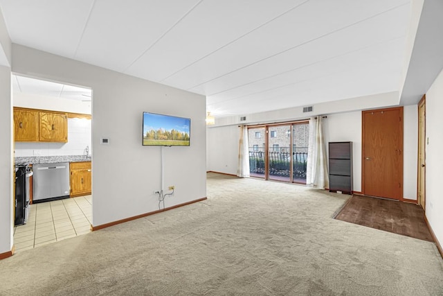 unfurnished living room with light colored carpet, baseboards, and visible vents