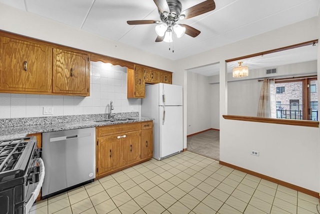 kitchen featuring stainless steel appliances, visible vents, brown cabinets, and a sink