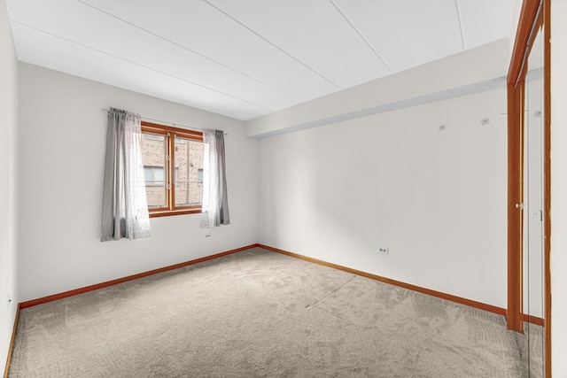 spare room featuring baseboards and carpet