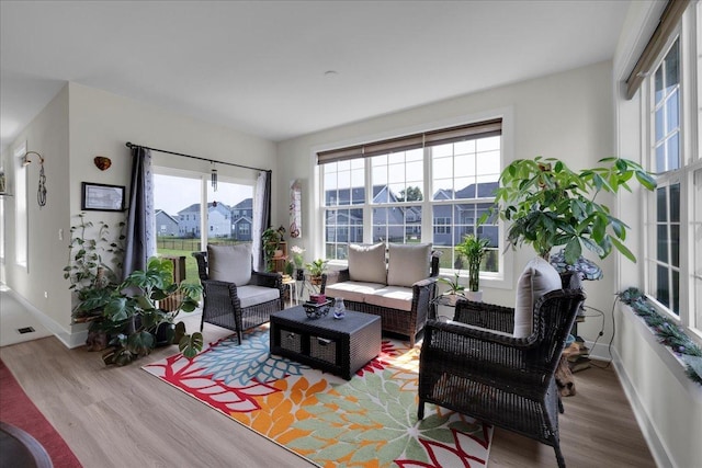living room with light wood-style flooring, a wealth of natural light, and baseboards