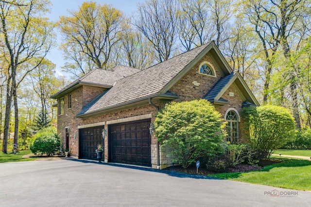 14705 W Mayland Villa Rd, Lincolnshire, IL 60069 - view of home's exterior featuring asphalt driveway, brick siding, and an attached garage