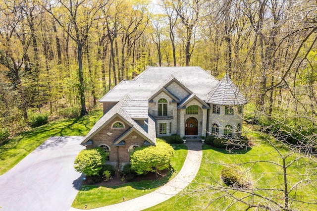 14705 W Mayland Villa Rd, Lincolnshire, IL 60069 - french country style house featuring stone siding, a front lawn, a view of trees, and brick siding