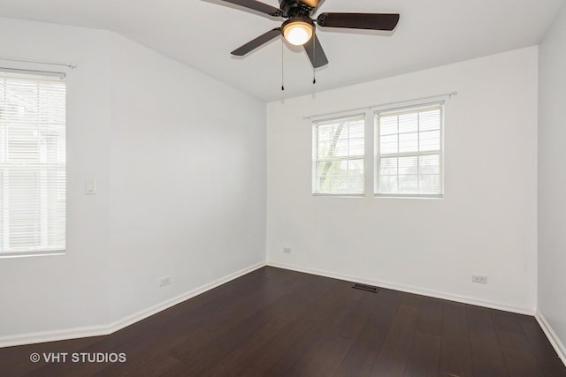 spare room with a ceiling fan, baseboards, visible vents, and dark wood-style floors