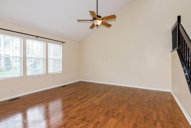empty room with visible vents, a ceiling fan, wood finished floors, and lofted ceiling