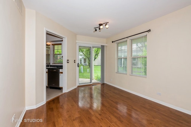 spare room featuring visible vents, baseboards, and wood finished floors