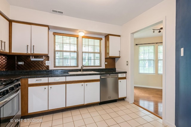 kitchen featuring visible vents, white cabinetry, a sink, appliances with stainless steel finishes, and backsplash