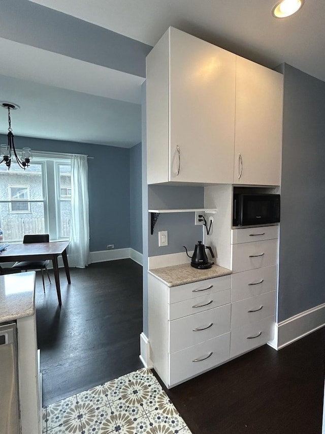 7525 S Crandon Ave, Chicago, IL 60649 - kitchen with hanging light fixtures, a sink, stainless steel appliances, white cabinetry, and under cabinet range hood