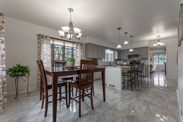 dining room featuring marble finish floor, baseboards, a chandelier, and visible vents