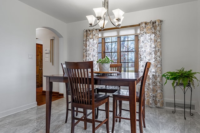 dining room with arched walkways, visible vents, marble finish floor, and a notable chandelier
