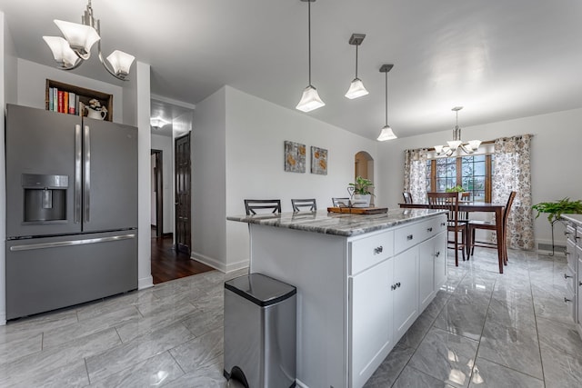 kitchen with marble finish floor, baseboards, a notable chandelier, and stainless steel fridge