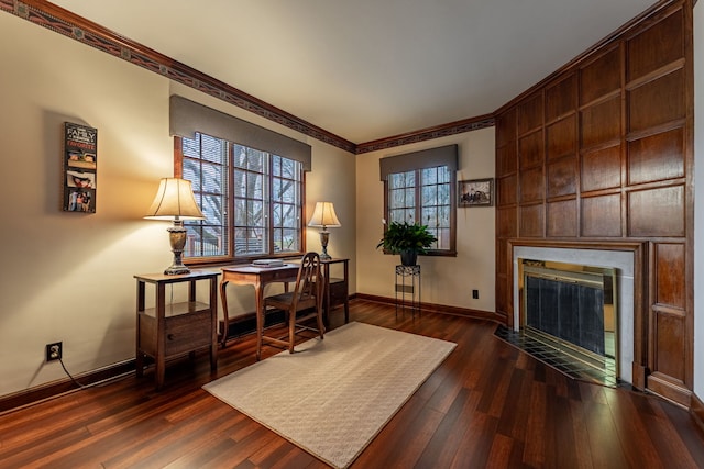 sitting room featuring a fireplace with flush hearth, wood finished floors, baseboards, and ornamental molding
