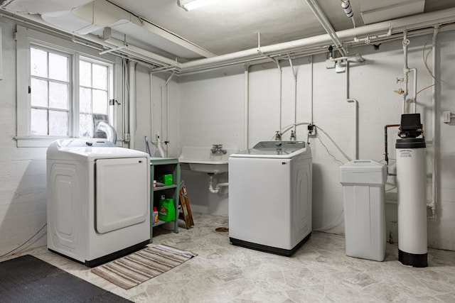 clothes washing area featuring washer and clothes dryer and a sink
