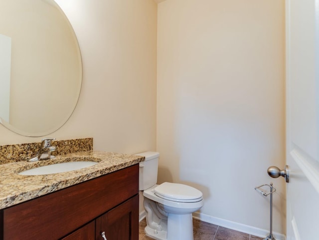 bathroom featuring toilet, tile patterned floors, vanity, and baseboards