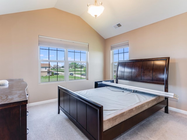 bedroom with lofted ceiling, light colored carpet, and baseboards