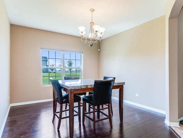 dining room featuring a chandelier, dark wood-style flooring, and baseboards