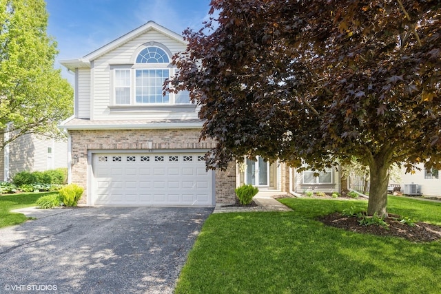 view of front of house featuring brick siding, a garage, and a front lawn