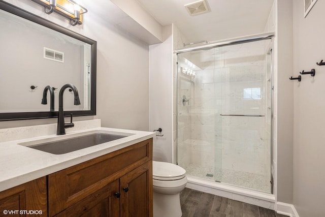 full bath with toilet, a stall shower, wood finished floors, and vanity