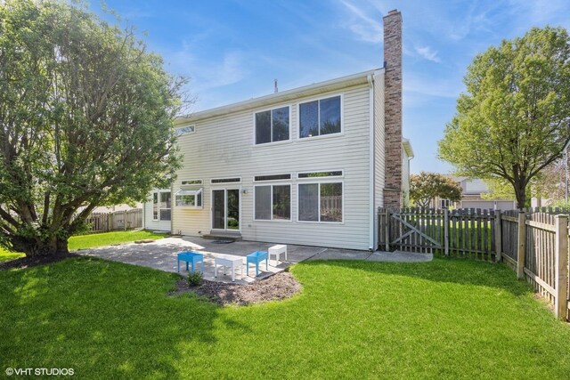 back of house featuring a chimney and a patio