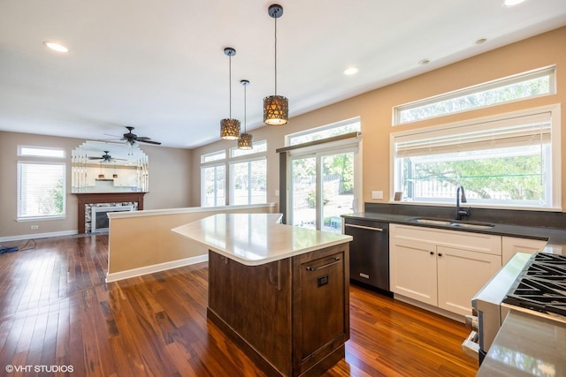 kitchen featuring stainless steel dishwasher, a sink, plenty of natural light, decorative light fixtures, and recessed lighting