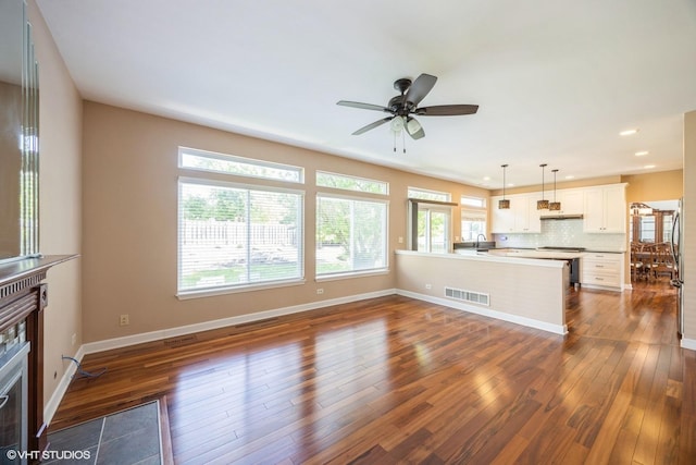 unfurnished living room featuring dark wood-style floors, ceiling fan, baseboards, recessed lighting, and a sink