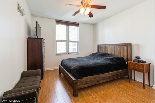 bedroom featuring light wood finished floors, baseboards, and a ceiling fan