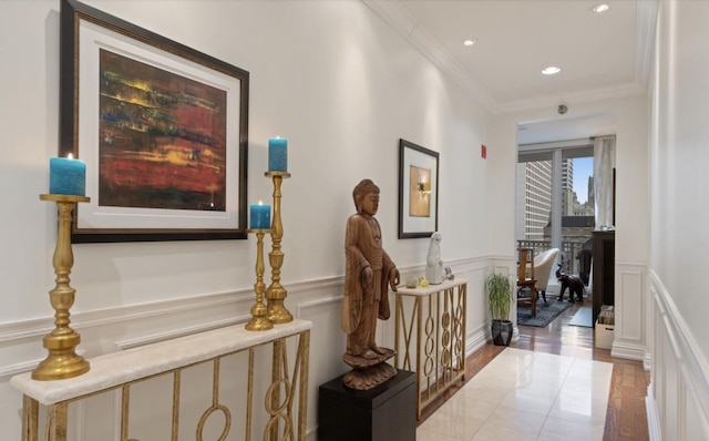 hall featuring ornamental molding, recessed lighting, a wainscoted wall, a decorative wall, and wood finished floors