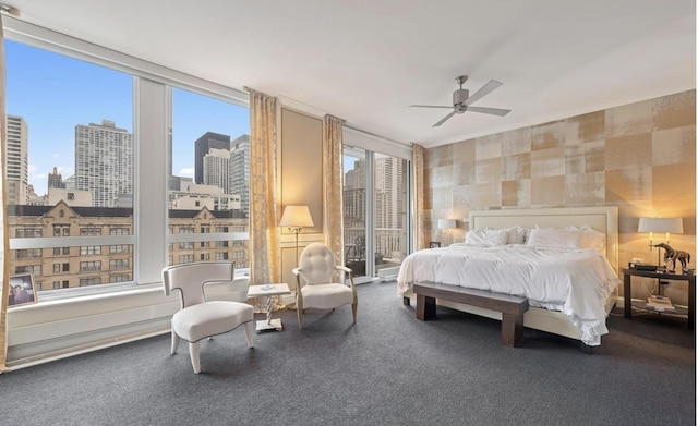 bedroom featuring a city view, floor to ceiling windows, and a ceiling fan