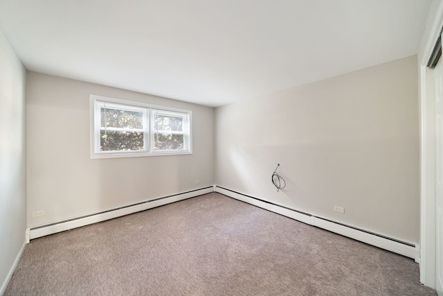 carpeted spare room with a baseboard radiator