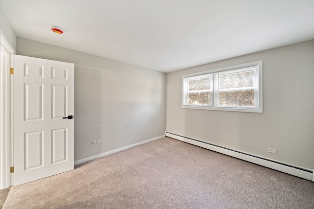carpeted empty room featuring a baseboard radiator and baseboards