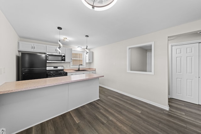 kitchen with freestanding refrigerator, stainless steel microwave, light countertops, a sink, and range with gas cooktop