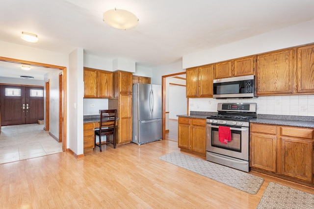 2084 Maplewood Cir, Naperville, IL 60563 - kitchen featuring tasteful backsplash, brown cabinets, dark countertops, and stainless steel appliances