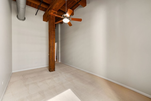 unfurnished bedroom with baseboards, wooden ceiling, light colored carpet, and lofted ceiling with beams