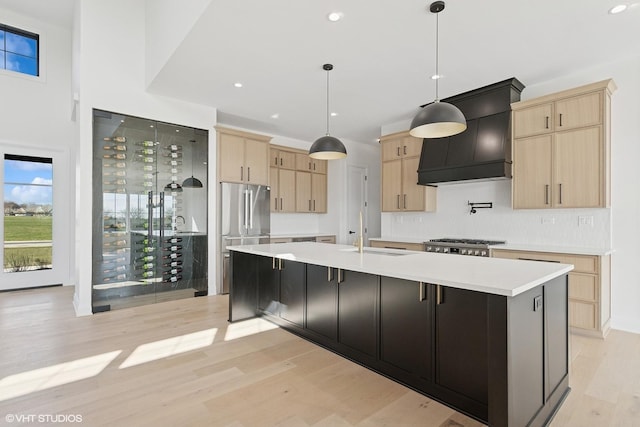kitchen with custom exhaust hood, light wood-style floors, and light brown cabinets
