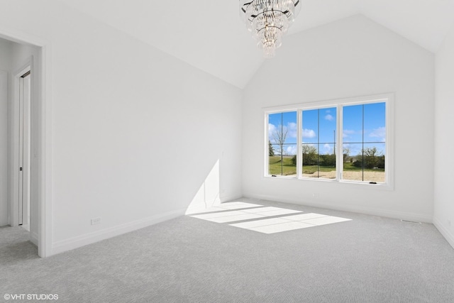 carpeted empty room with an inviting chandelier, baseboards, and vaulted ceiling