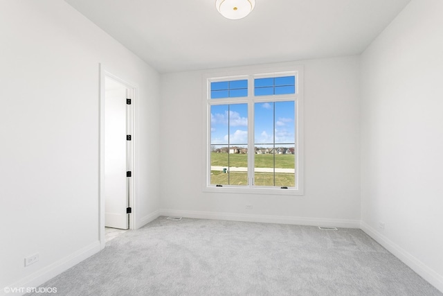 empty room with light carpet, visible vents, and baseboards