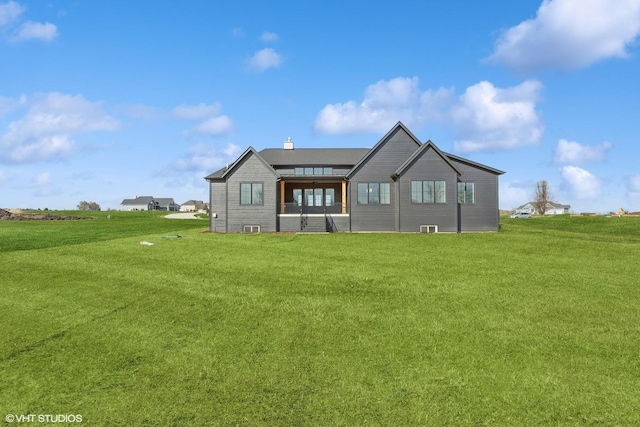 rear view of house with a lawn and a chimney