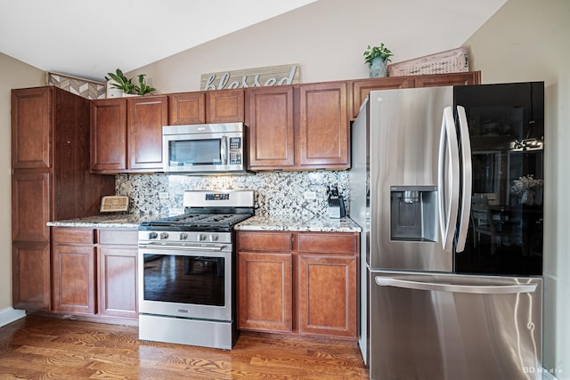 6834 Oak View Ct, Oak Forest, IL 60452 - kitchen featuring appliances with stainless steel finishes, lofted ceiling, light stone counters, backsplash, and light wood-type flooring