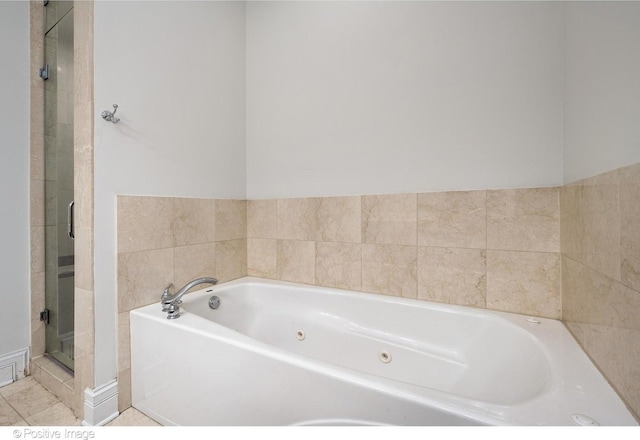 bathroom featuring a whirlpool tub and a shower stall