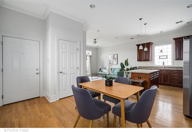 dining space with ornamental molding, light wood-style flooring, recessed lighting, and baseboards