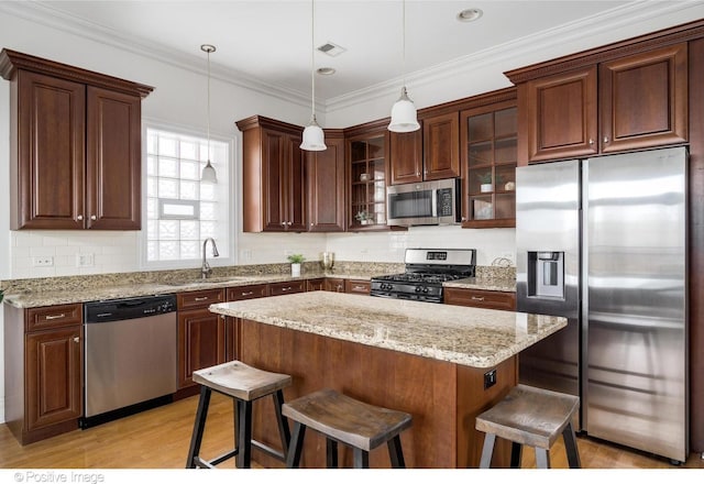 kitchen with stainless steel appliances, a sink, a breakfast bar area, glass insert cabinets, and tasteful backsplash