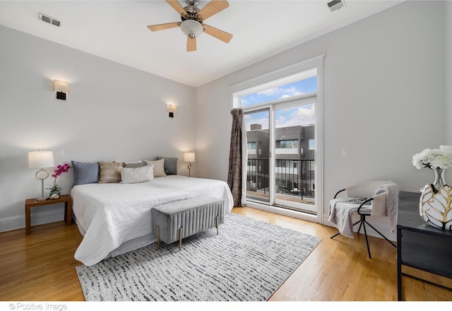bedroom featuring access to exterior, light wood-style floors, a ceiling fan, baseboards, and crown molding
