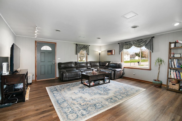 living room featuring visible vents, crown molding, and a wealth of natural light