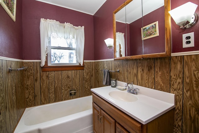 bathroom featuring vanity, a tub, and wainscoting