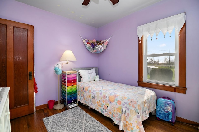 bedroom featuring ceiling fan, baseboards, and wood finished floors
