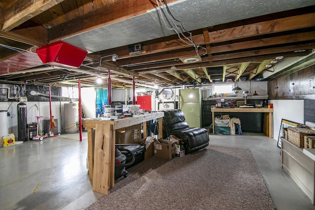 below grade area featuring water heater, freestanding refrigerator, a wealth of natural light, and a workshop area